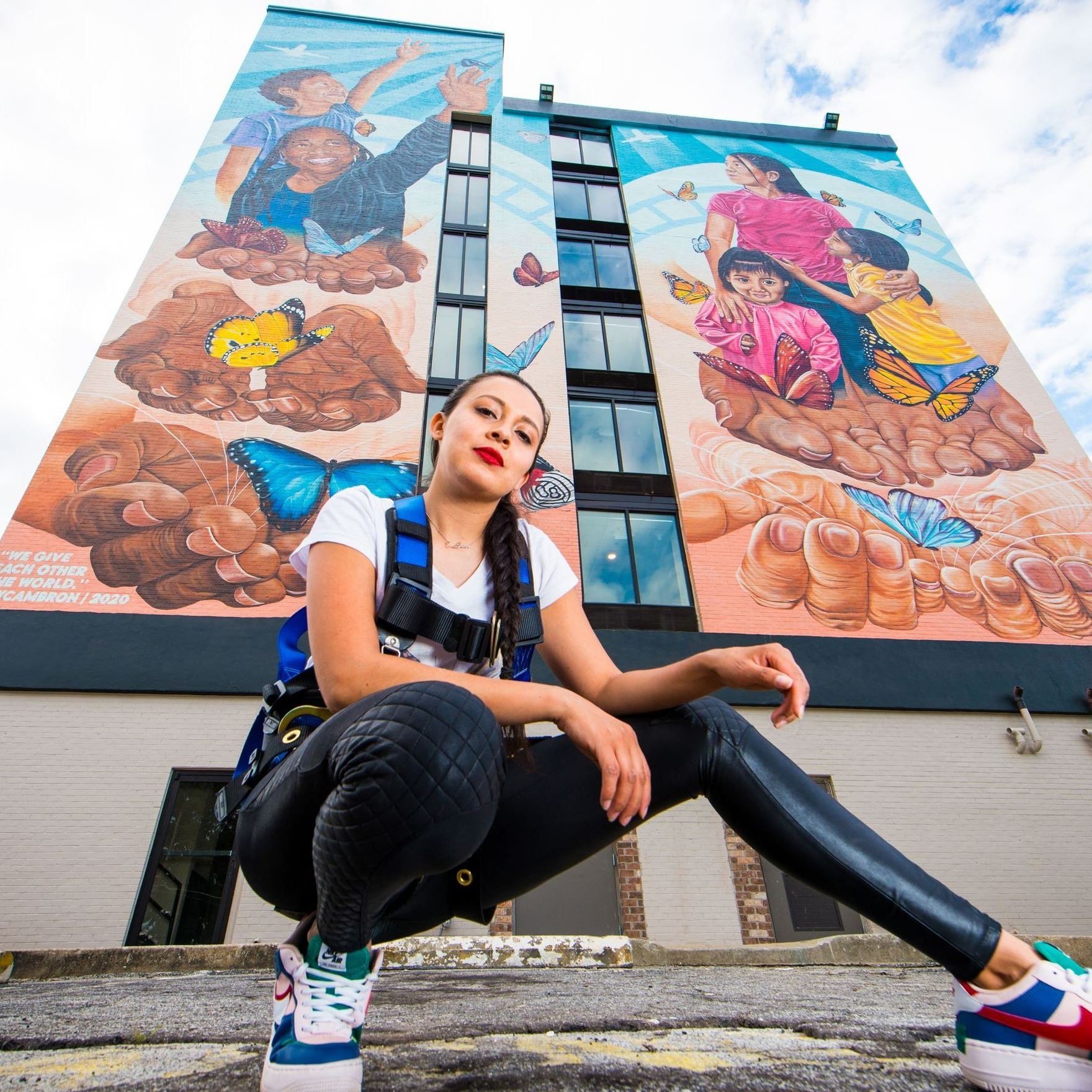 Artist Yehimi posing in front of Hapeville Mural